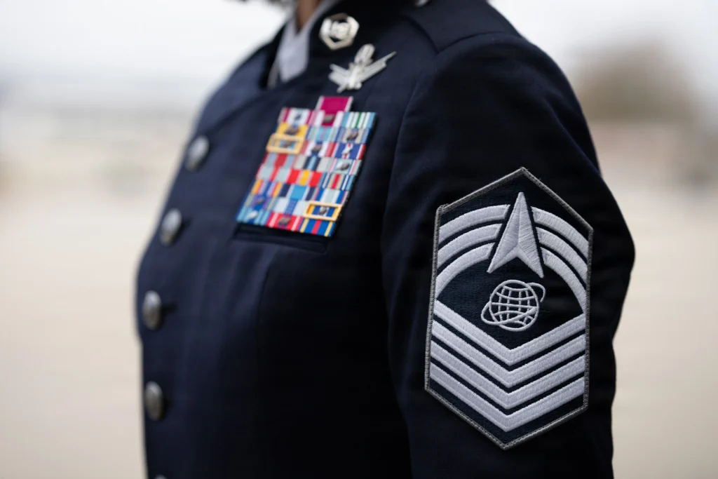 U.S. Space Force service dress uniform displaying military ribbons, badges, and insignia on a blue jacket